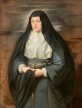 A standing older woman shown from the knees up wearing a long gray nun’s habit, or robe