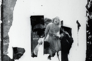 A destroyed film negative cell featuring a woman and two men.