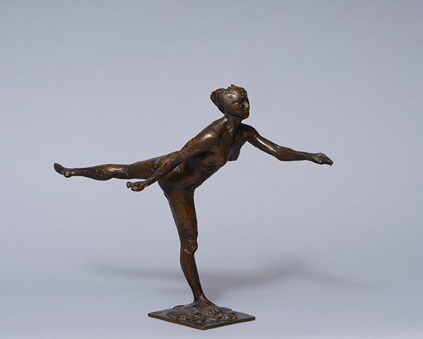 A bronze sculpture of a dancer balancing on one leg, the other leg extended back with arms outstretched in opposite directions