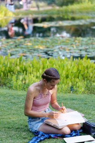Young woman drawing on the grass